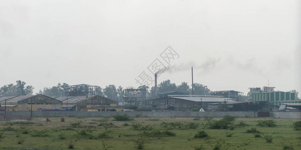 一个被农村田和夏季草地包围的中小型村工业区图片