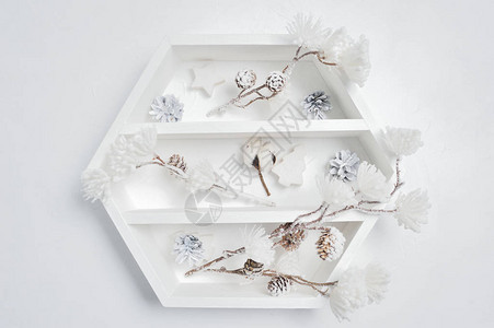 带有圣诞装饰品的装饰白色书架花柜棉花和白冬花放在桌上图片