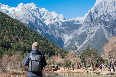 在丽江古城附近玉龙雪山景区内的地标和热门景点蓝月谷旅行的年轻旅行者云南丽江独背景图片