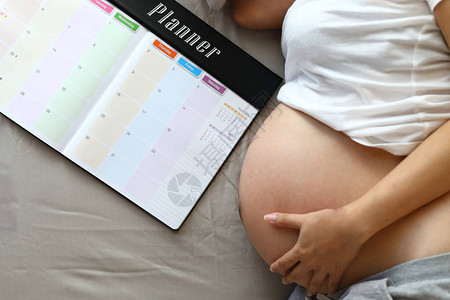 妈怀孕产妇手抱肚子爱宝妈写计划表记图片