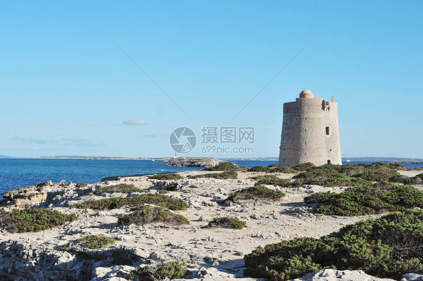 西班牙伊比萨岛中世纪TorredeSesPortes塔和背景中的邻近Formente图片