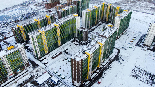 冬季城市景象环绕着新的适应建筑和雪覆盖的地面图片