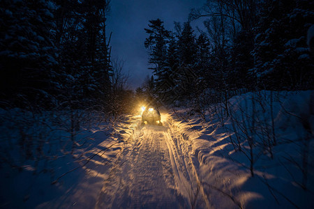 晚上的雪地摩托穿过冬季大灯穿过冬季的夜路雪图片