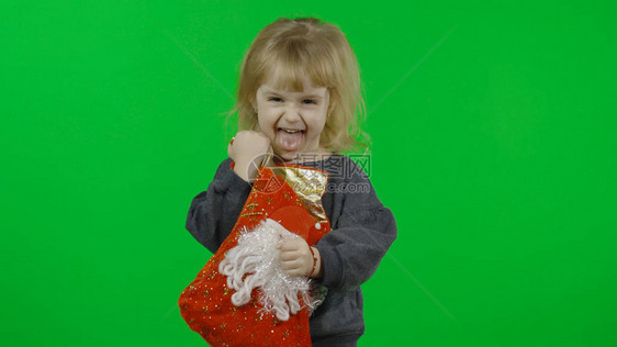 穿着毛衣的快乐美丽的小女婴与雪人圣诞节的概念寻找圣诞袜中的礼物积极漂亮四岁的孩子做鬼脸和图片