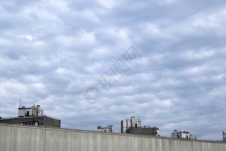 在寒冬阴云天的蓝天空中白云的背景城市房屋的顶在图片