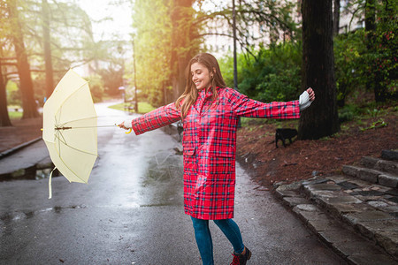 一个美丽的女人撑着伞走路的肖像图片