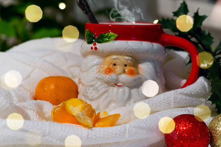 一杯圣诞老人的杯子盛着热茶和橘子长满了绿图片