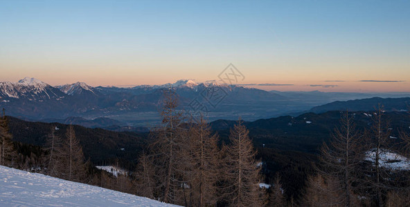 壮观的冬天山全景山在日落太阳在白雪皑的山脊和山峰后落山斯洛文图片