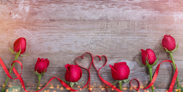 旧桌子上的玫瑰和丝带红心图片