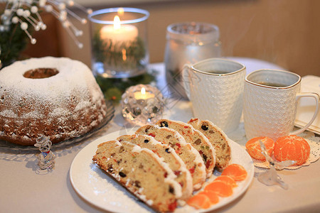 在茶具圣诞树枝和点燃的蜡烛的背景上图片