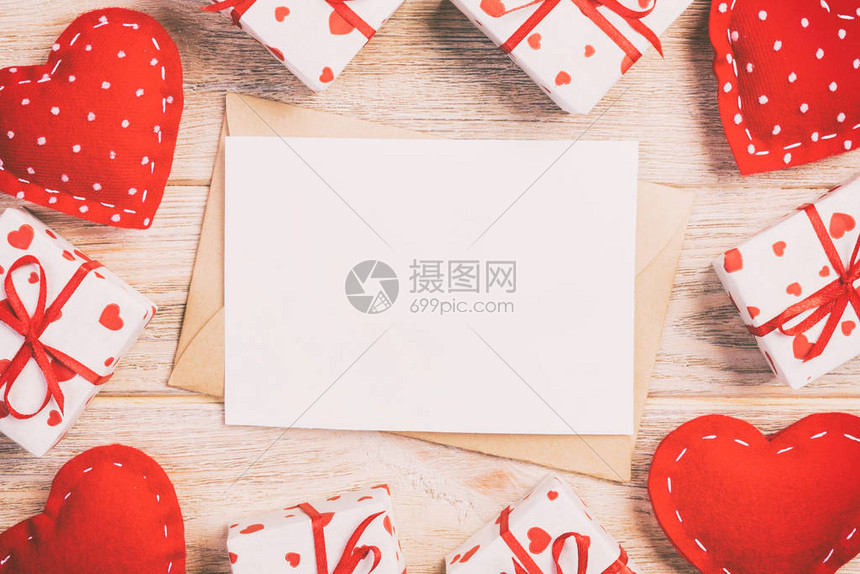 用红色的心和礼品盒在橙色木制背景的信封邮件情人节贺卡爱情或图片