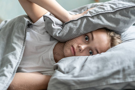 失眠的女人睁着眼睛躺在床上清晨的时间失眠和睡眠问题放松和睡眠的概念感到困倦和疲倦早点起床放松图片