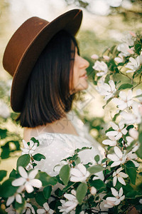 在春天花园里享受树上香气的模糊波西米亚女孩的背景下图片