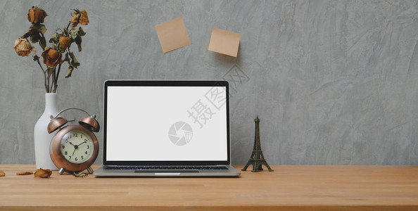 用空白屏幕笔记本电脑和装饰在有顶壁灰背景的木桌布上的旧图片