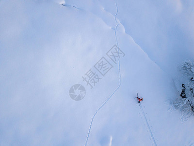 登山者在雪覆盖的偏远地区与旅游滑雪一起向上远足的鸟瞰图野图片