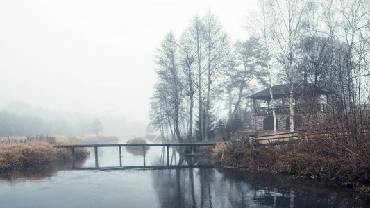 雾气缭绕的河岸上的木桥图片