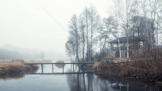 雾气缭绕的河岸上的木桥图片