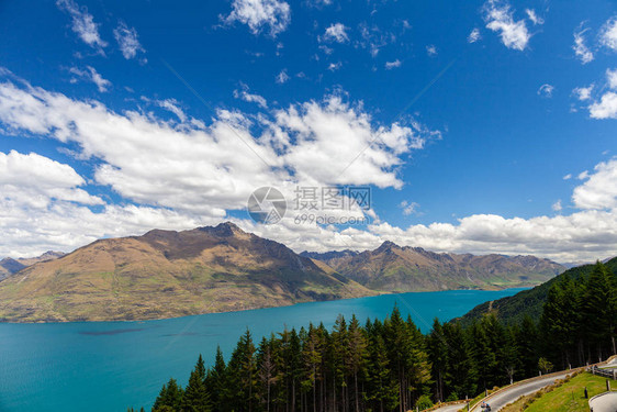 美丽的风景与高岩石与照明的山峰山湖中的石头反射蓝天和日出时的黄色阳光图片