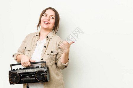 年轻的卷发女人拿着复古式收音机点图片