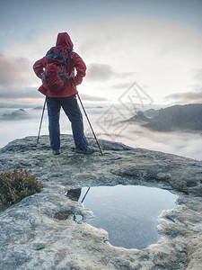 年轻女游客站在山顶上寻找迷雾无处图片