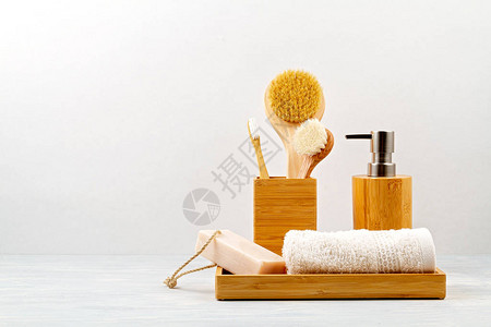 用于沐浴的竹子配件碗皂液器刷子牙刷毛巾和用于个人卫生的有机干洗发水浴室内部的零浪费无塑料背景图片
