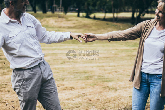 可爱的老年微笑夫妇男人和女人在浪漫的时刻在公园里跳舞温暖的心婚姻和情人的结合和关系夫妻相爱快乐的图片