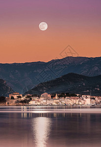 满月在科西嘉海岸城镇圣佛罗伦特上空升图片