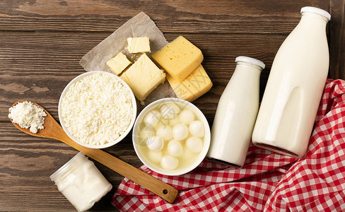 木制深色乡村背景上的乳制品和酸奶产品牛奶开菲尔酸奶黄油奶酪分类平面布局顶视图复制空图片