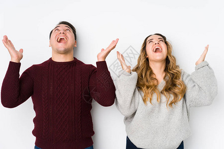 年轻一对穿着白色背景的情侣向天空尖叫图片素材