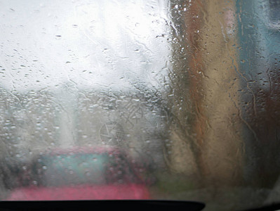 汽车玻璃后面的雨滴顺着汽车玻璃流下来车内挡图片