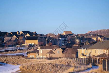 寒冬美国城市的一部分有棕色房子在阳光明媚的天地上枯草和雪图片