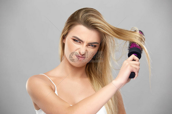 不满意的女孩梳着长的浅棕色头发图片