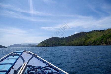 从一艘船向菲律宾群岛的大森林岛屿行驶的景色小岛周围环绕着蓝色平静的海水和蔚图片
