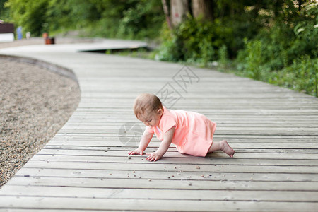 有选择的焦点快乐6个月的孩子穿着粉红色的衣服爬图片