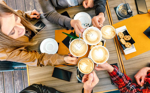 朋友们在咖啡店餐厅烤卡布奇诺的顶视图千禧一代学生团体在时尚咖啡吧一起享用早餐自助餐厅饮料概念采用生动背景图片