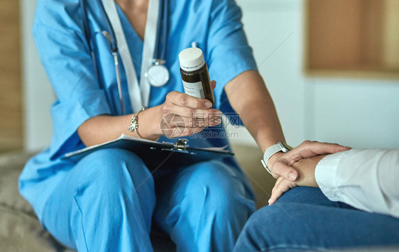 美丽的微笑女人在一瓶药丸的医生提供病人来自合法商店的灵丹妙药或拯救生命的抗抑郁药为健康的生活方式规定图片