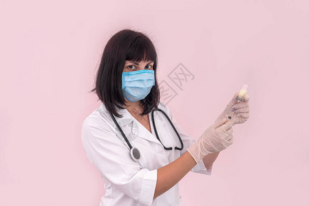 在粉红色上隔离的注射用医生填充注射器图片