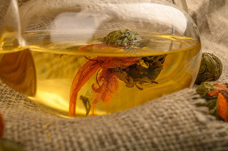 鲜花茶泡在玻璃茶壶和花生茶球中背景是粗背景图片