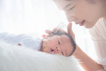 亚洲母亲早上用爱母亲与孩子的概念抚摸她新生的孩子图片