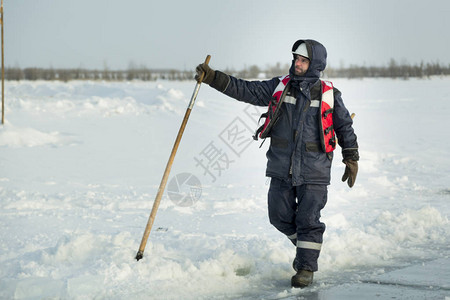 在冰冻湖冰上工作的工人手里拿着混凝图片