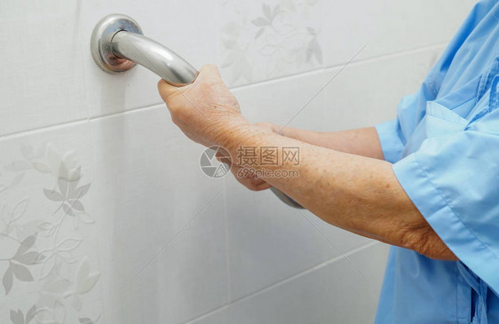 亚洲老年或老年妇人患者在护理医院病房使用厕所浴室把手安全图片