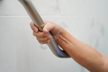 亚洲老年或老年妇人患者在护理医院病房使用厕所浴室把手安全图片