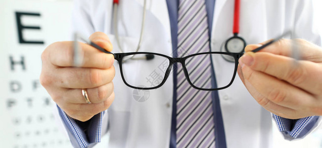 男医学生手给病人一副黑眼镜视力测试和矫正优秀视力激光手术替代驾驶员健康图片