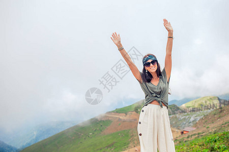 美丽快乐的年轻女子在山的雾背景图片