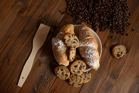 早餐卡布奇诺羊角面包和美味的饼干图片