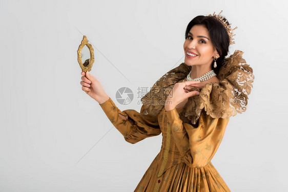 带着皇冠握着镜子的微笑的皇后在图片