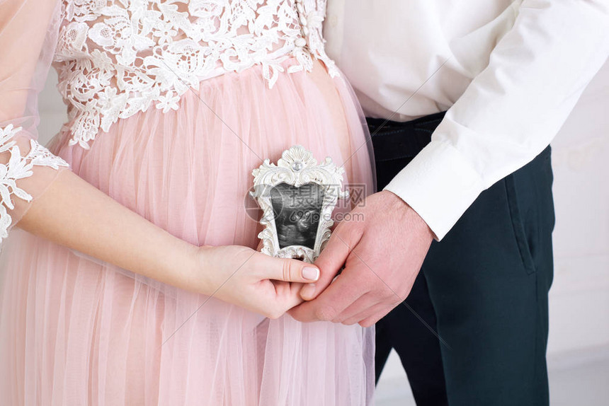 怀孕为人父母的概念幸福的夫妇有怀孕的消息怀孕的夫妇手里拿着婴儿的超声波扫描健康的父母手握孩图片