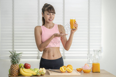 一杯草莓汁亚洲女孩完成锻炼后在家亲手做橙子汁背景