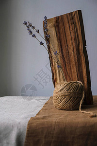 乌克兰粗糙的墙壁背景上亚麻桌布上的卷轴上的木头和薰衣图片