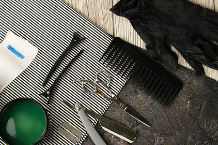 将理发工具剪刀危险剃须刀片露水和绿色发胶放在一条漂亮的条纹毛图片